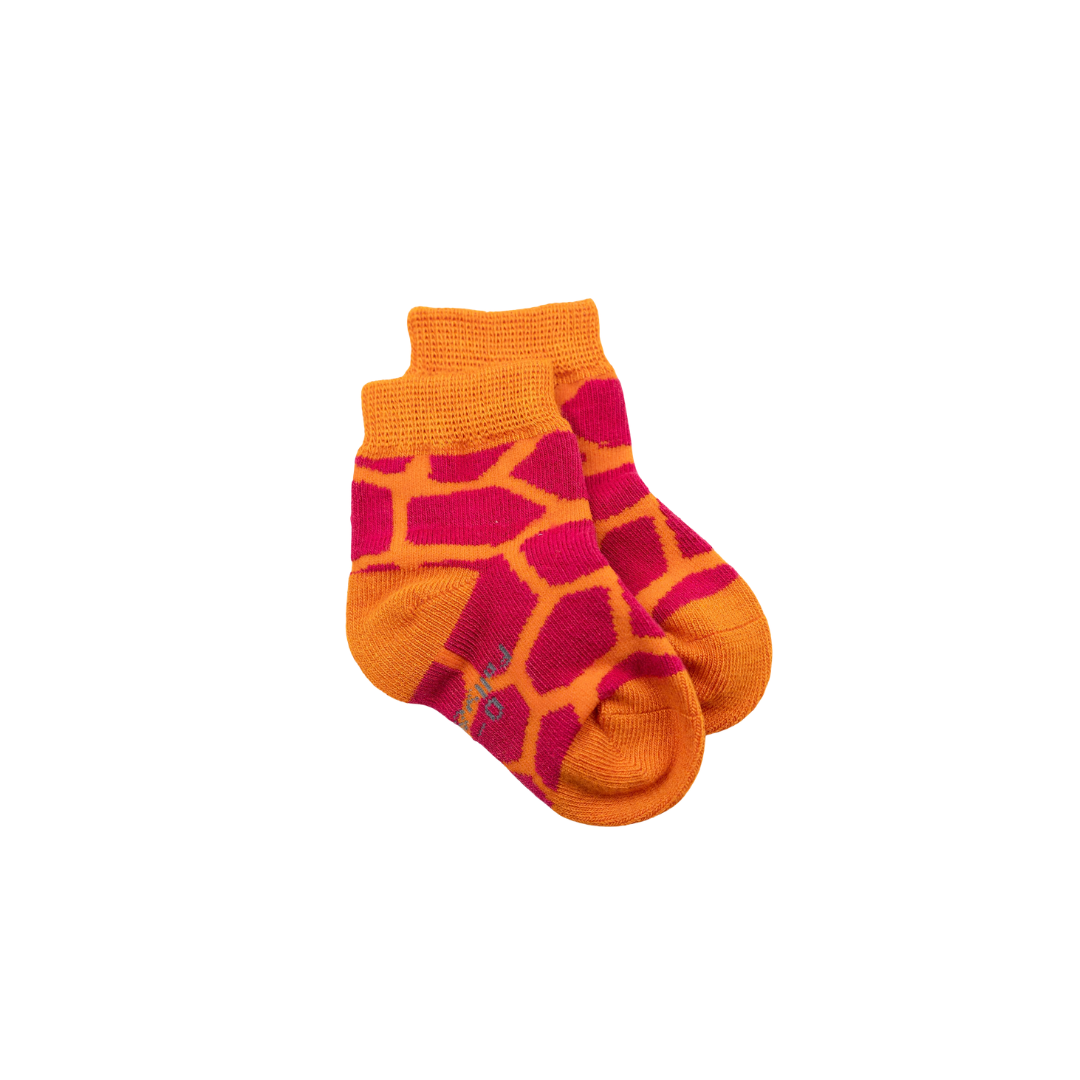 A pair of crew baby bamboo seamless socks featuring a giraffe-inspired pattern with bright orange and red sections, shown against a plain white background.
